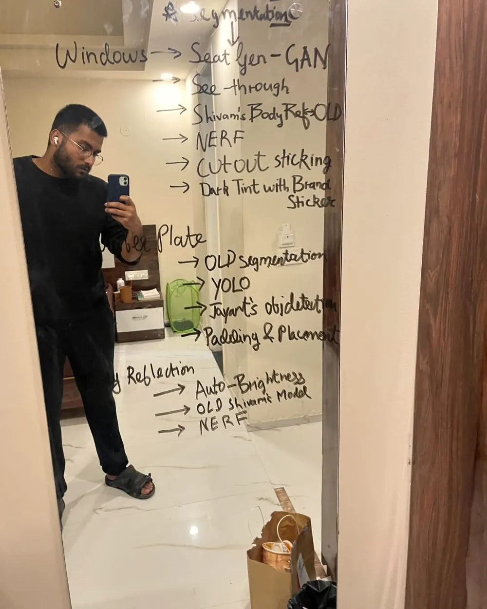 Anurag at a glass wall covered in handwritten notes on segmentation, YOLO, GAN, NeRF and shadow models.