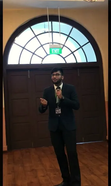Anurag speaking in a hall in Sydney